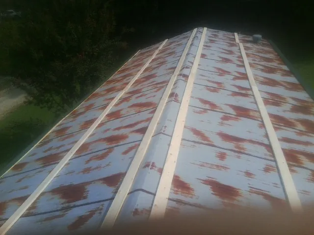 Rusted metal roof panels with new wood purlins before replacement — Storm Damage Roof Repair in Guilderland by Roofing Brothers