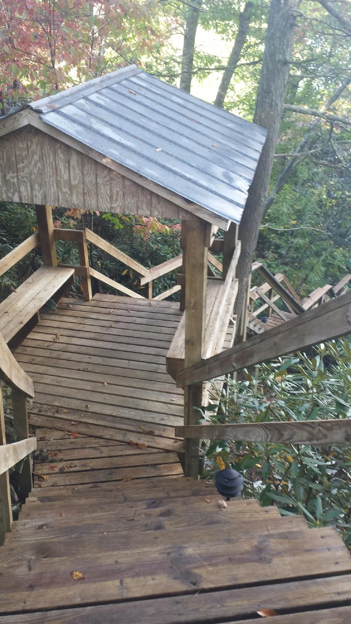 Metal roofed shelter over wooden steps on a wooded walkway — Skylight Repair & Installation work by our crew in Guilderland