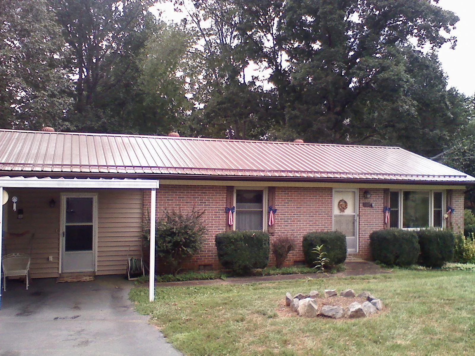 Bronze metal roof and carport on a brick ranch home — Roof Repair work by our crew in Guilderland